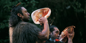 A man holding a large conch shell